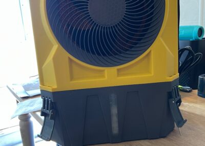Yellow and black industrial fan on table.