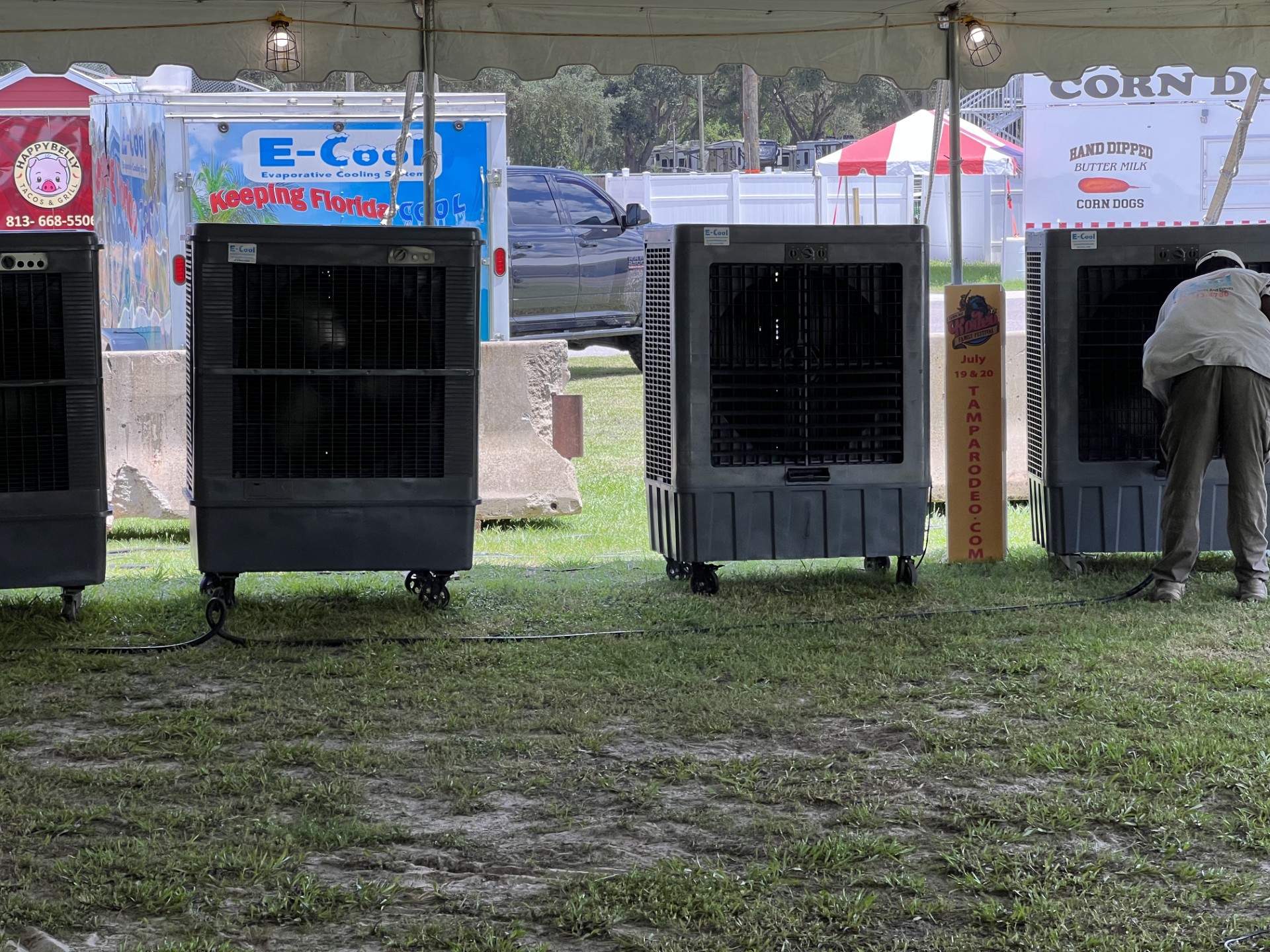 Evaporative coolers under tent at outdoor event.