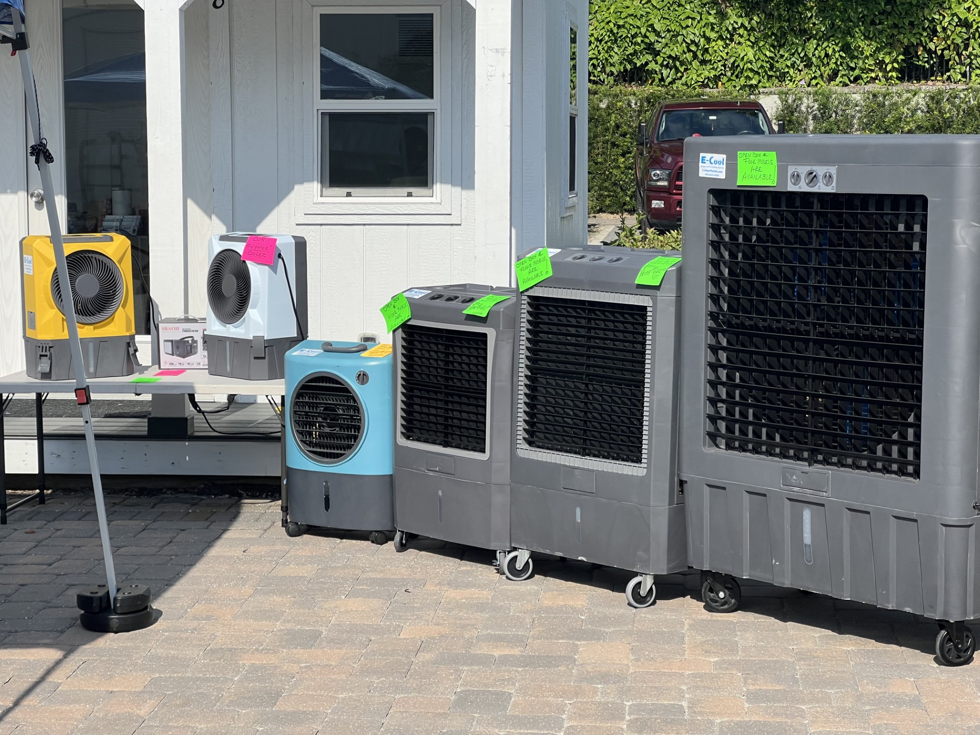 Various evaporative coolers displayed outside for sale.
