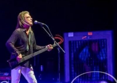 Musician performing on stage with a guitar.