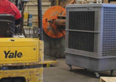 Forklift moving industrial fan in warehouse