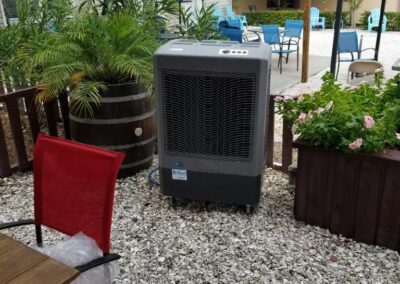 Outdoor cooling unit on patio near seating area