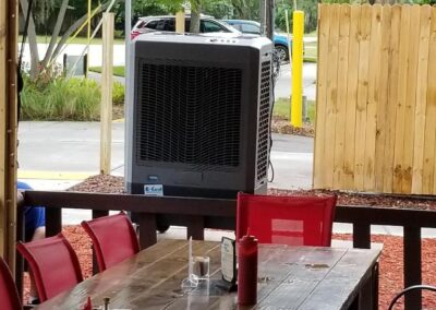 Outdoor restaurant dining area with red chairs and table.
