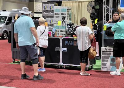 People browsing fans at a technology exhibit.