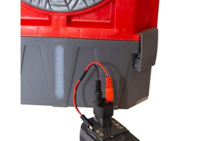 Battery pack connected to red industrial equipment.