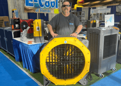 Man at E-Cool Florida booth with cooling fans.